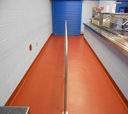 A bright orange floor in school room cafeteria shows off school spirit.