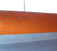 School accessway displays newly resurfaced self leveling floor system meeting red bricked wall.