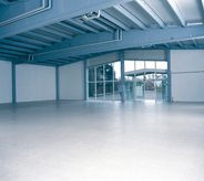 A bright white floor accents the open space in this large warehouse.